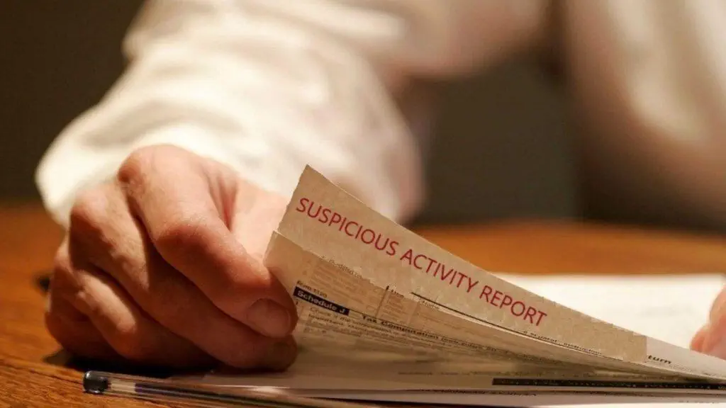 Close-up of hands reviewing a Suspicious Activity Report (SAR).