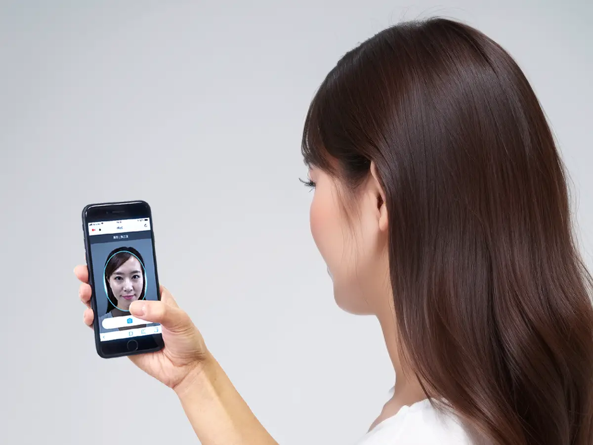 Woman using phone for facial recognition, complying with Australian KYC regulations.