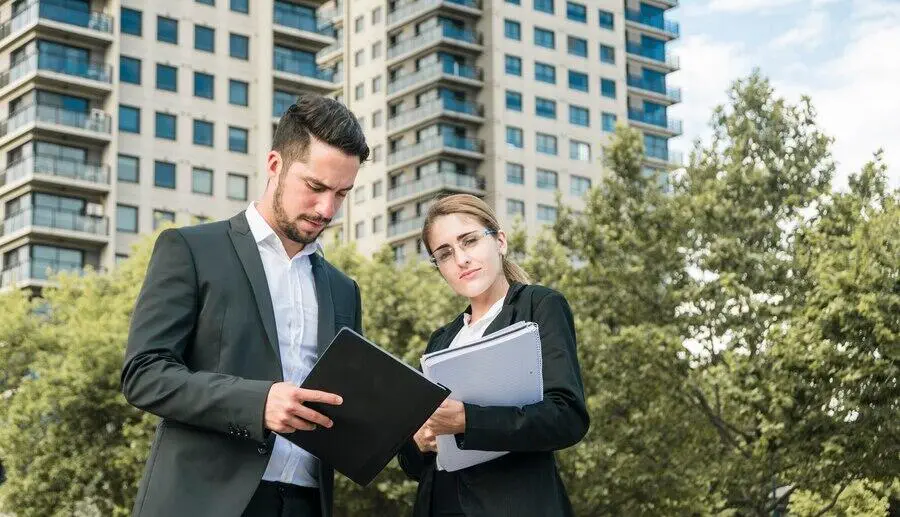 Two business professionals reviewing documents outdoors. Australian AML/CTF compliance.